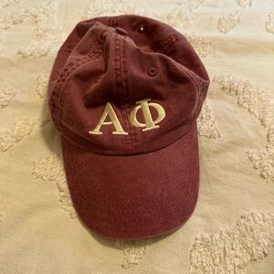 Crimson/burgundy faded Alpha Phi baseball cap.